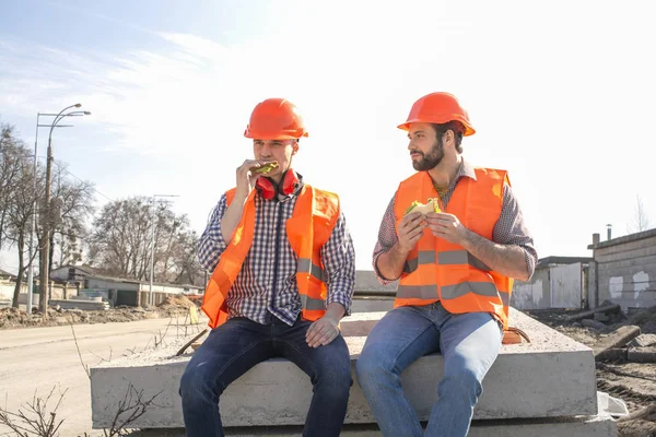 Dos Trabajadores Cascos Almuerzo Descanso Sentarse Losas Hormigón — Foto de Stock