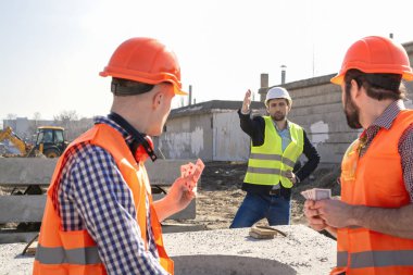 baş adam dinleniyor ve çalışmak istemiyorum kask işçilere bağırıyor