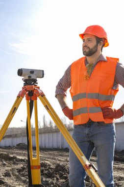 bir kask bir şantiye üzerinde çalışan bir cihaz ile erkek sörbe mühendisi