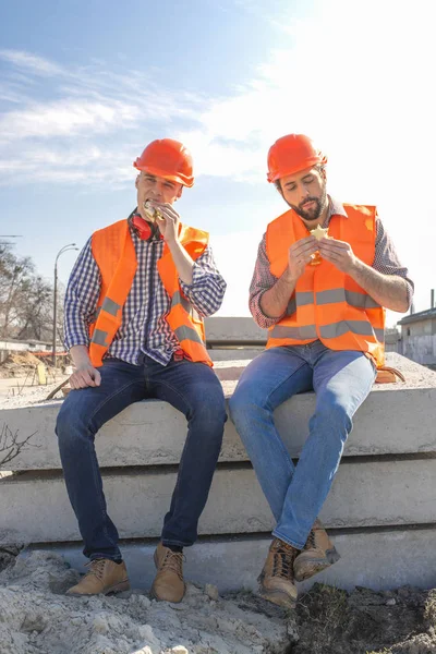 Deux Travailleurs Dans Les Casques Déjeuner Reposer Asseoir Sur Des — Photo