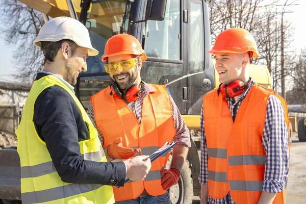 Ingenieros Trabajadores Masculinos Cascos Están Viendo Los Dibujos Cerca Excavadora — Foto de Stock