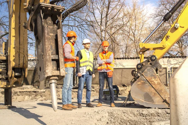 Ingenieros Trabajadores Masculinos Cascos Hablando Cerca Excavadora Excavadora — Foto de Stock