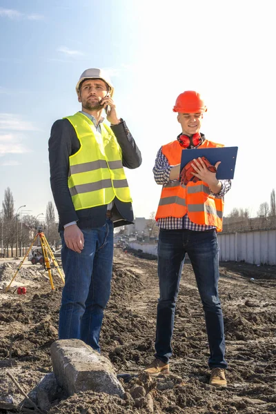 Two Men Builders Workers Engineers Construction Site Looking Drawings Helmets — Stock Photo, Image