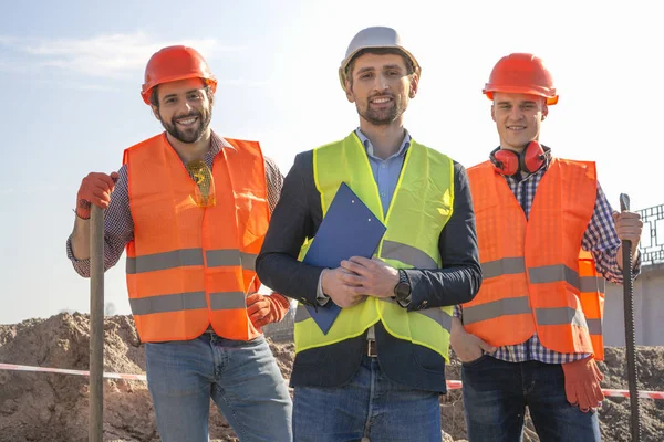 Trabalhadores Engenheiros Homens Capacetes Olhar Para Câmera Sorrir Canteiro Obras — Fotografia de Stock