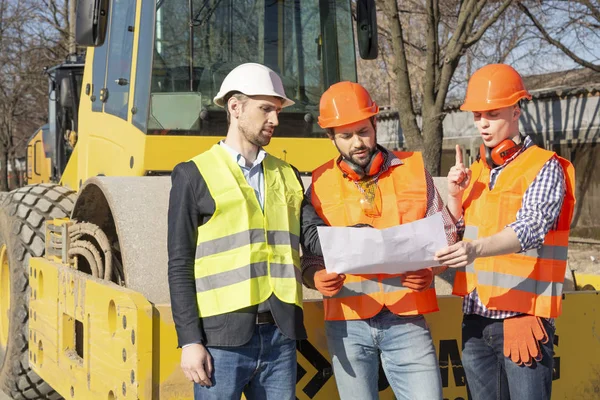 Male Workers Engineers Helmets Watching Drawings Bulldozer Excavator — Stock Photo, Image