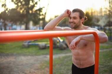 erkek atlet, kasları ile gövde, açık havada eğitim, gülümseyen, yatay bar