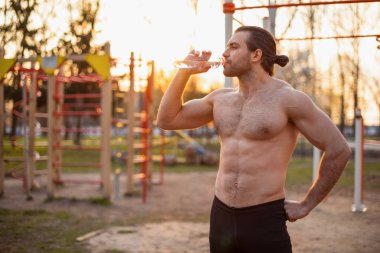 erkek atlet, kasları ile gövde, sokakta eğitim, bir şişe, shaker, spor beslenme su içme