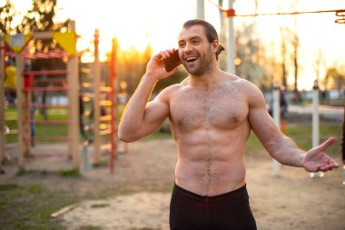 erkek atlet, kasları ile gövde, sokakta eğitim, telefonda konuşurken