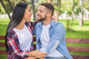 telefonda konuşurken bir bankta bir parkta sevgi dolu çift, yakışıklı adam ve kız