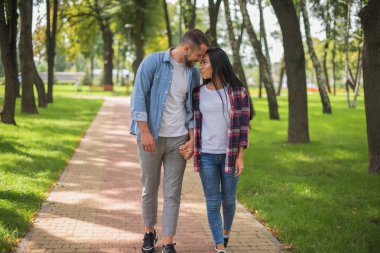 parkta yürüyen ve sarılma sevgi dolu çift, güzel adam ve kız