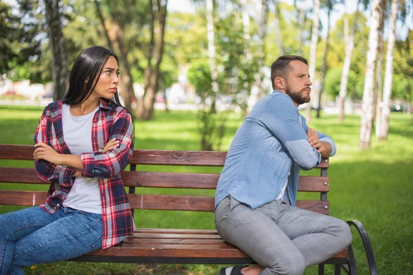 guy and girl on a bench in  quarrel on a park
