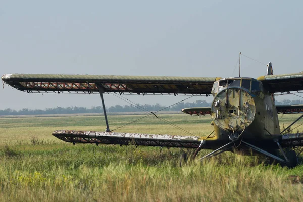 History of aviation. The old Soviet vintage biplane stands on the overgrown airfield