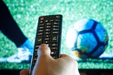 Birinin elini Tv Uzaktan kumanda futbol maç yayın sırasında tutar.   