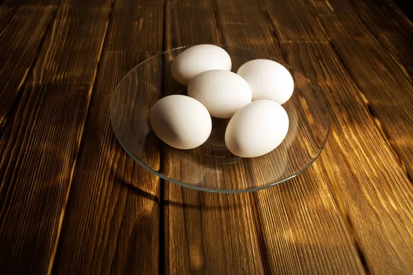Λευκό Κοτόπουλο Αυγά Μια Διαφανή Πλάκα Ένα Ρουστίκ Ξύλινο Τραπέζι — Φωτογραφία Αρχείου
