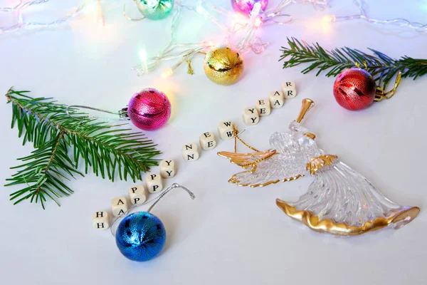 Ευτυχισμένος ο καινούριος χρόνος. Κύβοι με γράμματα, Άγγελος, πολύχρωμο παιχνίδια και ένα κλαδί χριστουγεννιάτικο δέντρο σε μια ελαφριά επιφάνεια. — Φωτογραφία Αρχείου