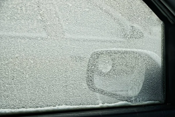 Vista desde el coche durante la tormenta de nieve de invierno. Ventana congelada del coche . — Foto de Stock