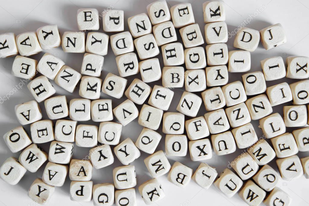 Cubes with letters of the English alphabet lie on a white background. View from above. Learning and literacy.                         