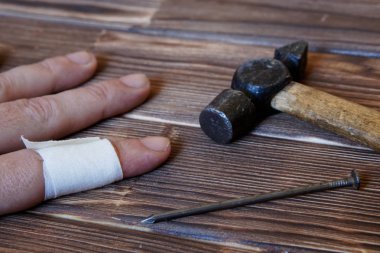 Birleştiriciyi yaralı el. Çivi ve çekiç. Parmak üzerinde çekiç. Marangozluk çalışmaları yaralanma.                             