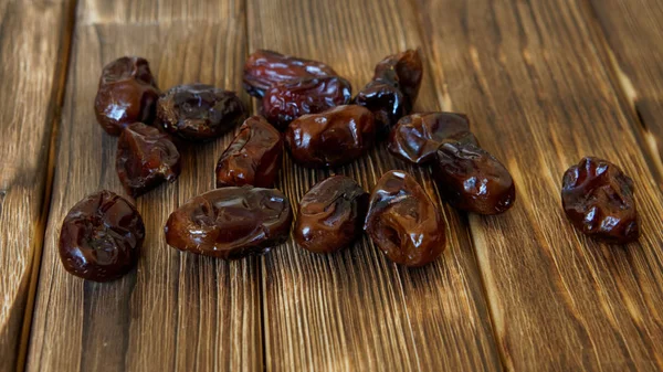 Dried dates lie on a wooden table. High-calorie foods.