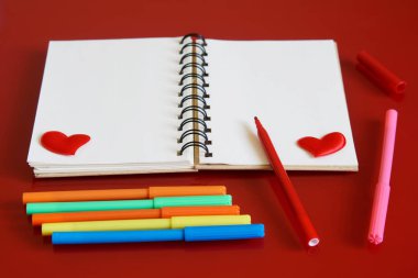 Kalpleri ve kırmızı bir arka plan üzerinde çok renkli keçeli kalemler ile not etmek. Sevgililer Günü'nde hazırlık için tebrikler. Şablon. St. Valentine's Day.                               