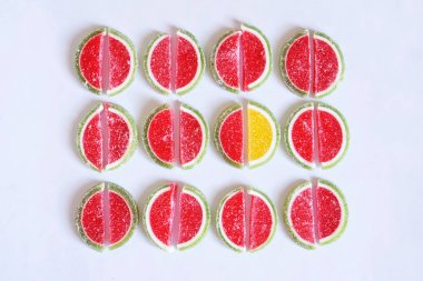 Marmelat dilim karpuz ve kireç beyaz bir yüzeye şeklinde. Kalabalıktan göze çarpıyor: bir sarı ve birçok kırmızı                      