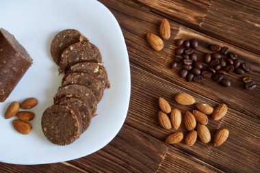Badem fındık, kahve taneleri ve çikolatalı pasta sosis bir ahşap yüzeyde. Rustik natürmort.                               