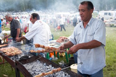 Askarovo Köyü, Başkurdistan, Rusya, - 2 Haziran 2011. Bir adam pulluk ulusal tatil kebap Sabantuy üzerinde-yapar. Tatar ve Başkurt tatil beyaz gıda. Rus Barbekü. 