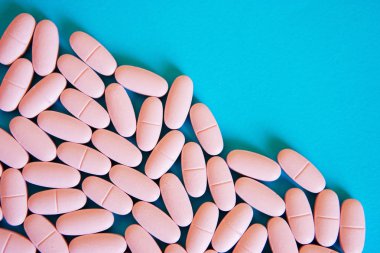 Mavi bir arka plan üzerinde pembe haplar. Köşegen. Sağlık ve tıp. Yukarıdan görüntülemek                          