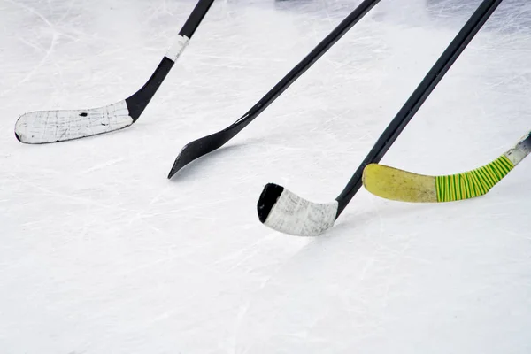 Four ice hockey sticks on the ice. Preparation for training in an open area. Winter sports.