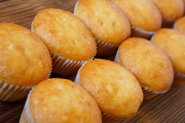 Gyllene cupcakes ligga på en yta av trä av furu styrelser. Välsmakande och hälsosam mat. Diagonal perspektiv och kort skärpedjup. Dagsljus — Stockfoto