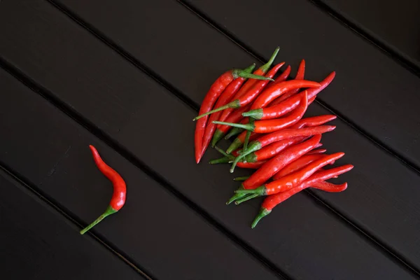 Röd chili skida ligga på svarta brädor — Stockfoto
