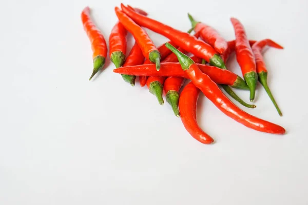 Baljor av red hot chili peppar ligga på en vit yta. Fritt utrymme för inskriptioner. — Stockfoto