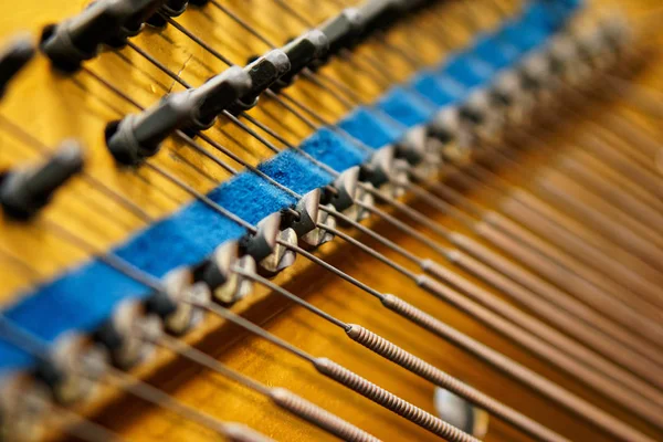 Колышки, памперсы и басовые струны внутри старого пианино. Механизм музыкальных инструментов . — стоковое фото