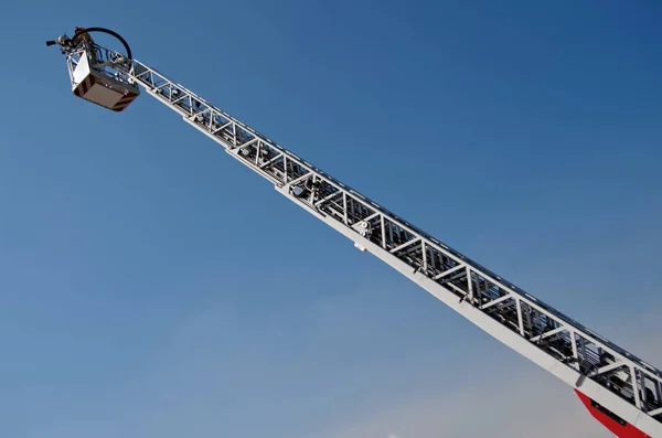 Fire truck lift in the blue sky. Putting out fires and saving people. Stock Photo