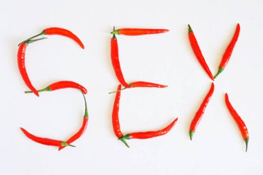 Beyaz bir yüzeyde kırmızı Chili Peppers, yazıt seks koydu. 