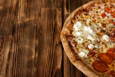 Kompozit karışık pizza çam panoları doğal ahşap yüzeyine. Gün ışığı. Yakın çekim. Kayıt için boş alan.