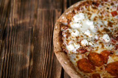 Kompozit karışık pizza çam panoları doğal ahşap yüzeyine. Gün ışığı. Yakın çekim. Kayıt için boş alan.