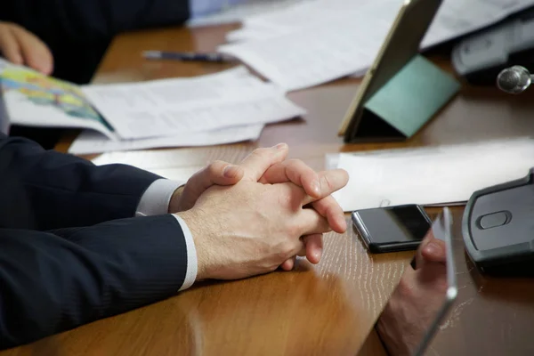 Bir iş toplantısı sırasında bir masada oturan bir kişinin elleri — Stok fotoğraf