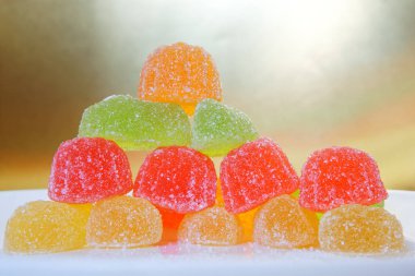 Altın ve beyaz arka plan üzerinde çok renkli marmelat demet