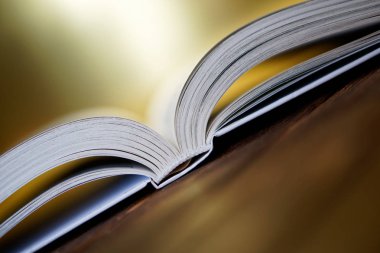 Açık kitap altın arka plan üzerinde kurullarında yalan söylüyor. Yakın çekim.