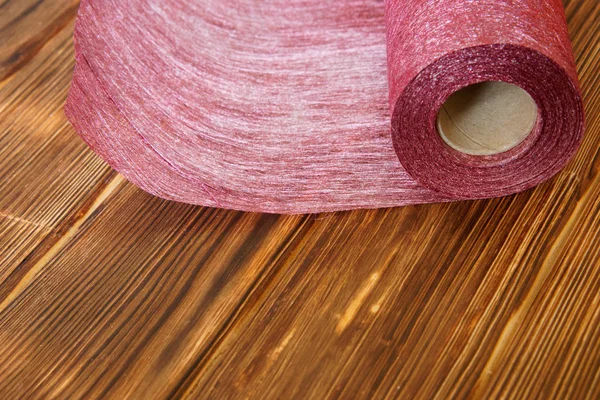 Roll of craft material from felt for home needlework on a wooden background from pine boards. — Stock Photo, Image