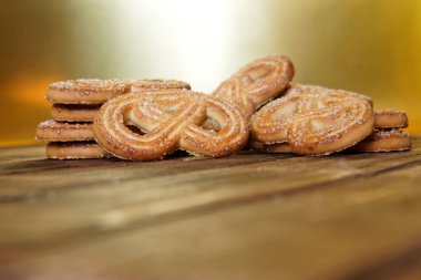 Şeker ile taze kurabiye doğal ahşap yüzey ve bir ve altın arka plan üzerinde yatıyor. Close.