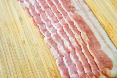 Bir bambu kesme tahtası üzerinde ince dilimlenmiş pastırma