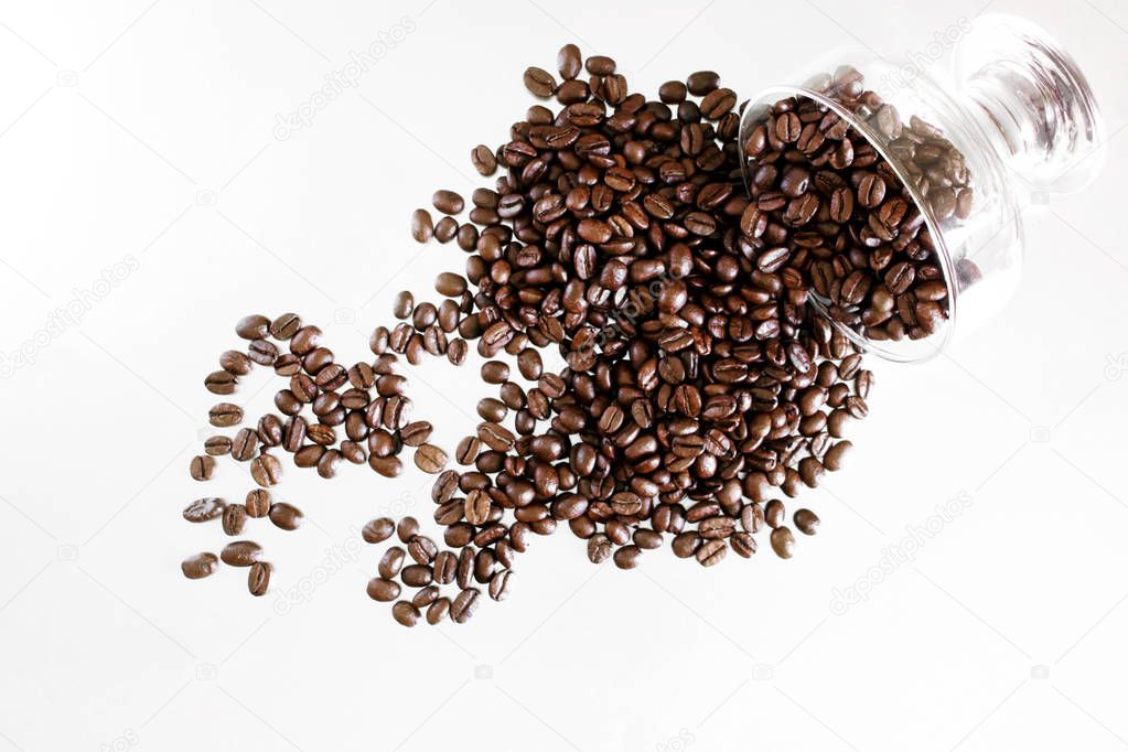 Roasted beans of Arabica coffee are poured out onto a light surf