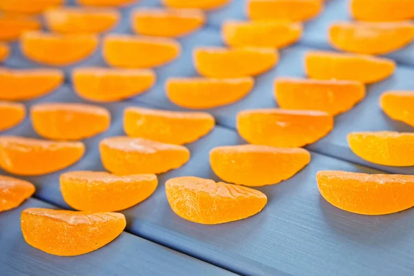 Marmelade en forme de tranches de mandarine sur une table à planches en bois — Photo