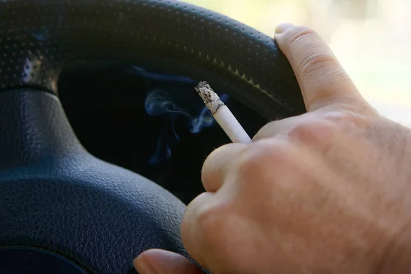 A male driver smokes a car. Harmful and dangerous habits. Traffi — Stock Photo, Image