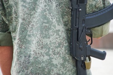 Arkasında silahı olan genç bir adam sokağa gidiyor. Devriye o