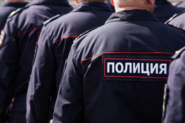 Russian police officers work on a city street. View from the bac