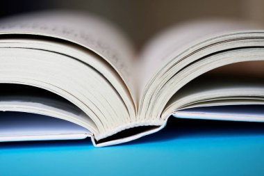 Açık bir kitap veya günlük mavi bir arka plan üzerinde yatıyor. Kolej veya scho