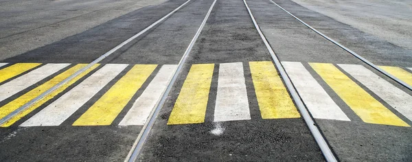 Verharde dwars loop over tramrails, gemarkeerd met witte en gele pa — Stockfoto